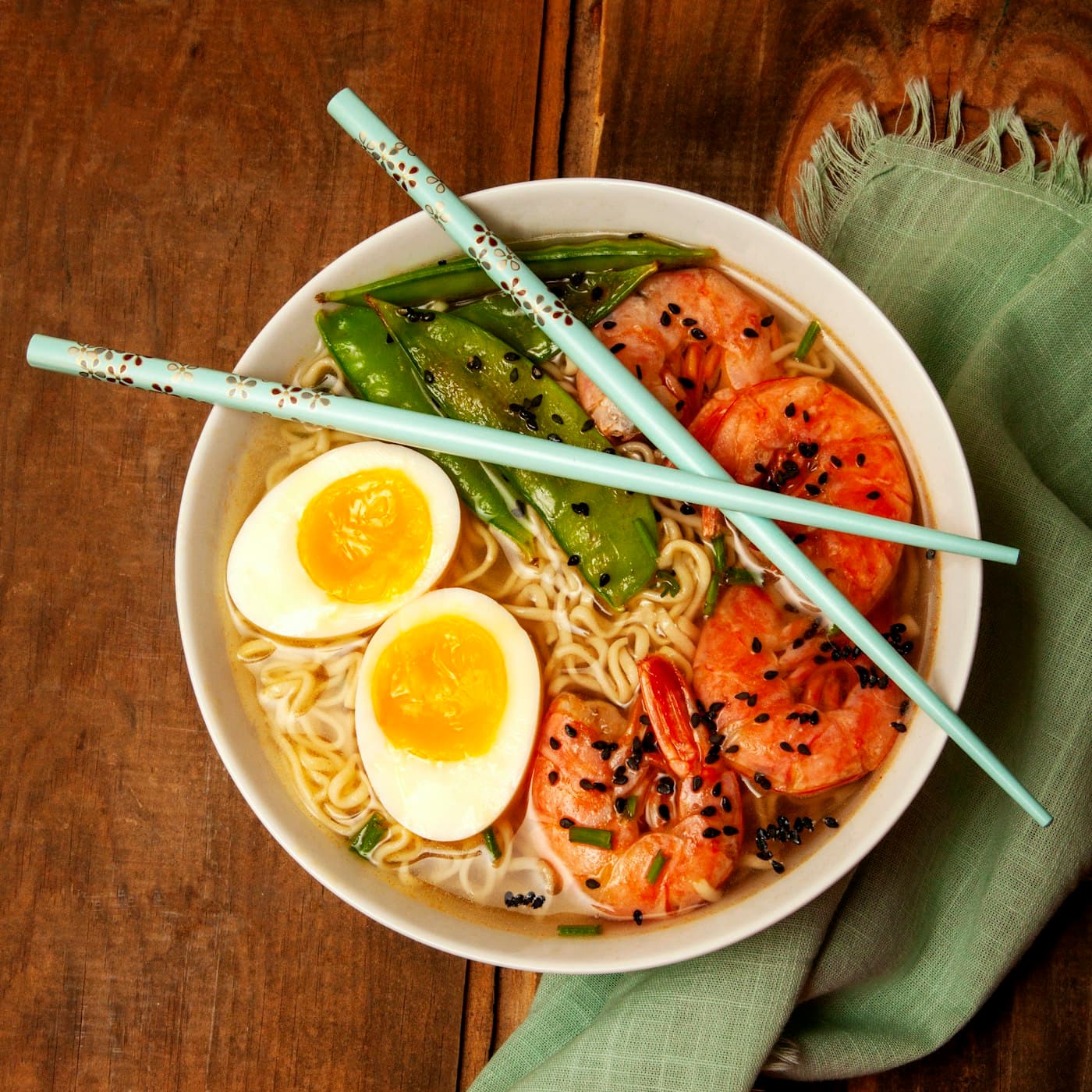 Bol de ramen aux crevettes et œufs marinés, baguettes posées dessus