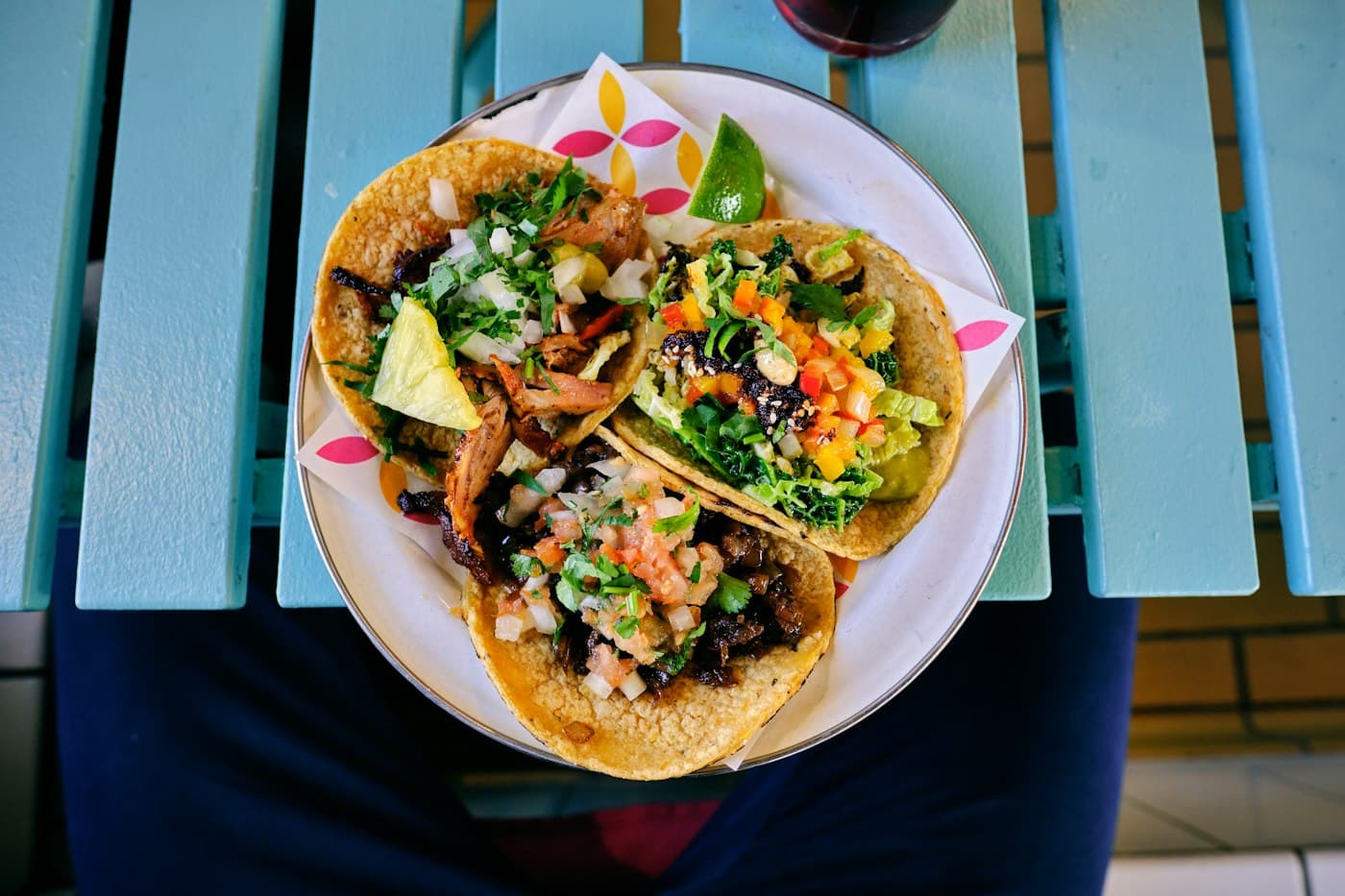Trois tacos garnis sur une assiette