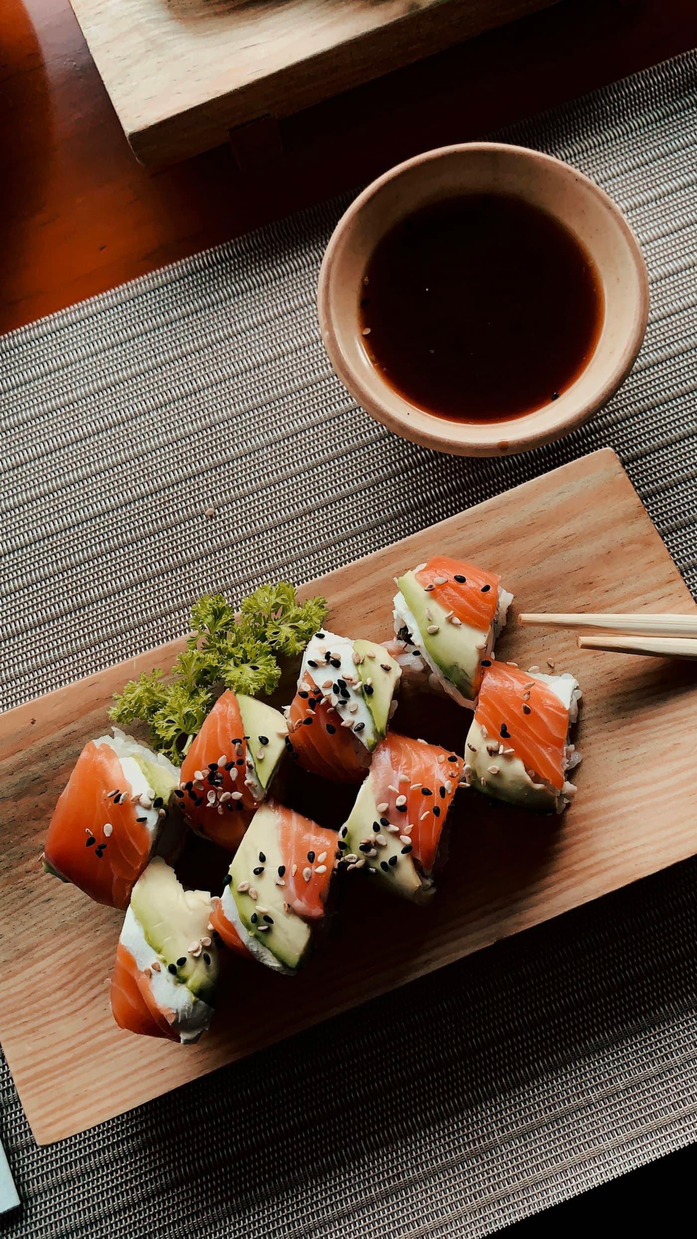Makis et sauce soja sur une planche en bois