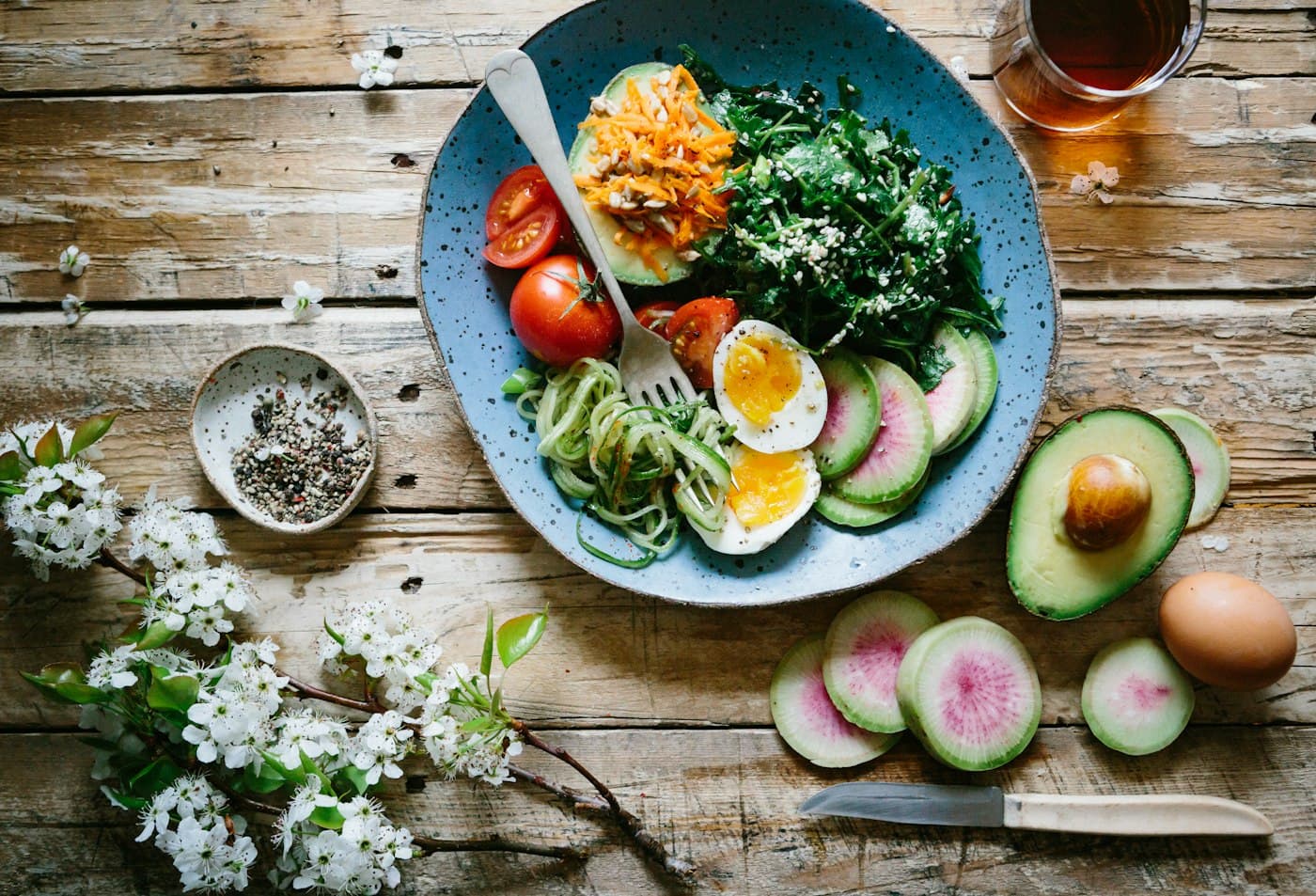Assiette de légumes, œufs et avocat sur une table en bois